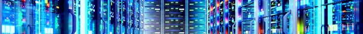 Row of illuminated server racks in a modern data centre, housing high-performance computing and AI infrastructure
