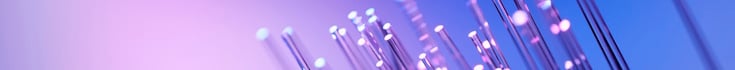 Abstract fibre-optic strands with glowing light points on a purple-to-blue gradient background