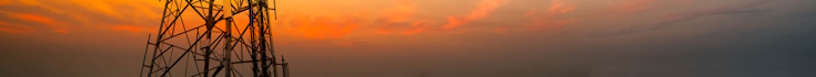 The base of a telecoms tower against the backdrop of a sunset
