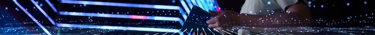Hand holding a device with a background of bright lights
